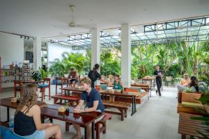 a group of people sitting at tables in a restaurant at Onederz Siem Reap in Siem Reap