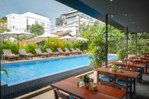 a swimming pool with tables and chairs next to a building at Onederz Siem Reap in Siem Reap