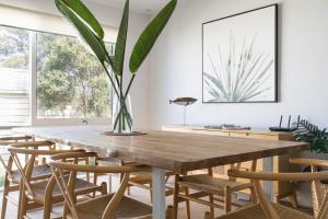 a dining room with a wooden table and a potted plant at The Hideaway - Coastal Chic Living in Blairgowrie