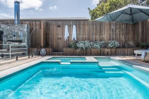a swimming pool in a backyard with a wooden fence at The Hideaway - Coastal Chic Living in Blairgowrie