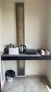 a kitchen counter with pots and pans on a shelf at Aashvi homes - Rooms with Balcony in Jaipur