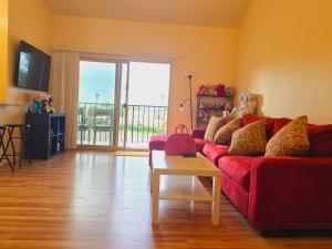 Una sala de estar con un sofá rojo y una mesa. en Mountain View Condo with Pool, en Tucson