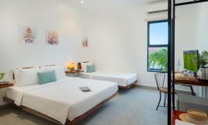 a hotel room with two beds and a window at Onederz Siem Reap in Siem Reap
