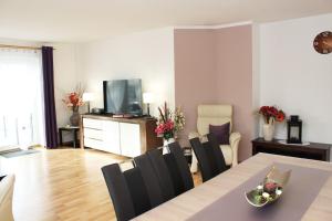 een woonkamer met een tafel, stoelen en een televisie bij Ferienhaus im Bleitz in Wrestedt