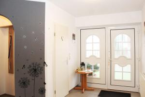 een hal met een witte deur en een tafel bij Ferienhaus im Bleitz in Wrestedt +20 foto's