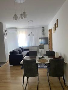 a living room with a table and a couch at Stan Na Dan Pehlić - Apartments For The Day Cazin in Cazin