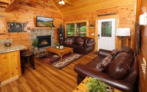 a living room with leather furniture and a fireplace at Bear Retreat in Pigeon Forge