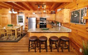 a kitchen with a island with bar stools at Bear Retreat in Pigeon Forge