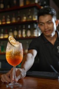 a man sitting at a bar with a drink at Onederz Siem Reap in Siem Reap
