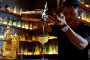 a man making a drink in a martini glass at Onederz Siem Reap in Siem Reap