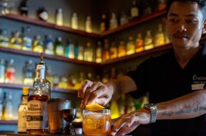 a man making a drink at a bar at Onederz Siem Reap in Siem Reap
