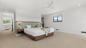 a bedroom with a large bed and a window at Pirama - The Vintage Holiday Houses in Pokolbin