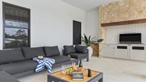 a living room with a couch and a table at Pirama - The Vintage Holiday Houses in Pokolbin