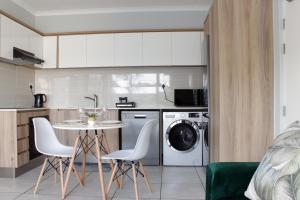 a kitchen with a washing machine and a table and chairs at The Jade Escape in Cape Town
