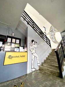 a mural of a man on a staircase in a building at The Pocket Hotel in Mactan