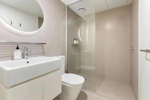 墨尔本Southside urban oasis的浴室里有洗手池、马桶和镜子。 更多11张照片