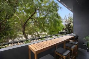 墨尔本Southside urban oasis的阳台配有木桌、椅子和窗户。