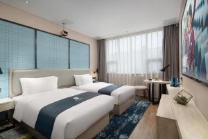 YisuheにあるEcharm Hotel Xiangtan Yichuanhe Branchのベッド2台とソファがあるホテルの部屋