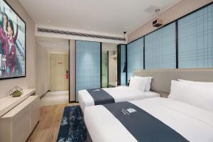 YisuheにあるEcharm Hotel Xiangtan Yichuanhe Branchのベッド2台とテレビがあるホテルの部屋