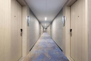 YisuheにあるEcharm Hotel Xiangtan Yichuanhe Branchの青い絨毯の建物の廊下