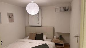 a bedroom with a bed and a pendant light at Meiringen Retreat - Sauna, Terrace & Pinball in Meiringen