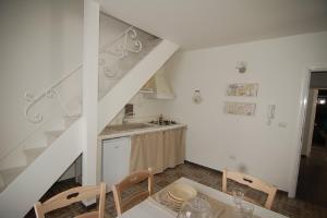 a kitchen with a dining table and a staircase at Domus Aurea in Martina Franca