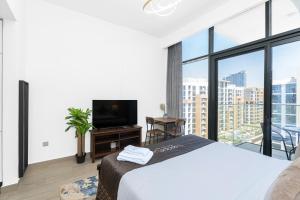 Escape24 Stylish Studio Azizi Riviera 8 Meydan one Dubai في دبي: غرفة نوم بها سرير ونافذة كبيرة