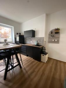 una cucina con tavolo in legno e un angolo cottura con frigorifero e piano cottura. di Sun & Moon Apartments Erfurt a Erfurt