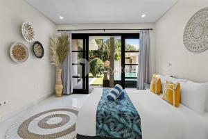 a bedroom with a bed and a glass door at Sombra Villa by Kozystay - Sanur in Sanur +30 photos