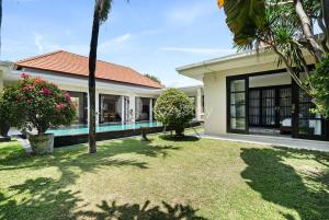 a house with a yard with a swimming pool at Sombra Villa by Kozystay - Sanur in Sanur