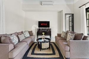a living room with two couches and a coffee table at Sombra Villa by Kozystay - Sanur in Sanur