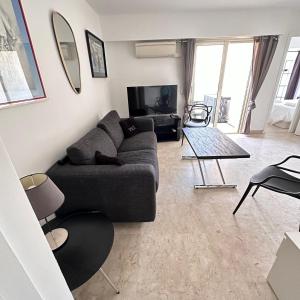 una sala de estar con un sofá y una mesa en 2P Between Croisette Beaches and Antibes Street, en Cannes
