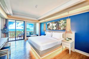ein Schlafzimmer mit einem großen Bett mit einer blauen Wand in der Unterkunft Beyond Kata in Kata Beach