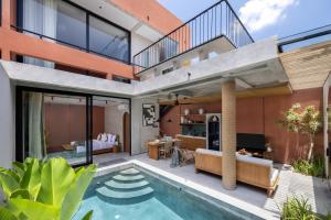 an open living area with a swimming pool and a house at Terra Villas Canggu in Canggu