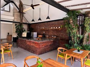 ein Restaurant mit Ziegelwand, Tischen und Stühlen in der Unterkunft Lubdhaka Canggu in Canggu