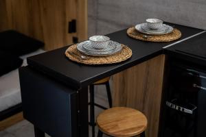 zwei Hüte auf einer schwarzen Theke mit einem Hocker in der Unterkunft Industrial - Le Petit Bati in Volos