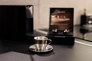 eine Tasse auf einem Teller auf einer Theke in der Unterkunft Industrial - Le Petit Bati in Volos