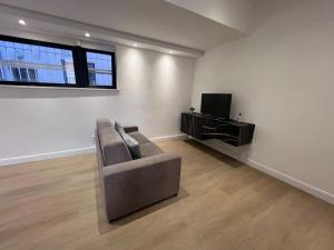 a living room with a couch and a tv at Castello Estense Luxury Apartment - Centro in Ferrara