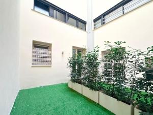 a courtyard with green plants on the side of a building at Castello Estense Luxury Apartment - Centro in Ferrara
