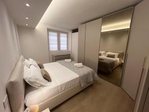 a bedroom with a large bed and a mirror at Castello Estense Luxury Apartment - Centro in Ferrara
