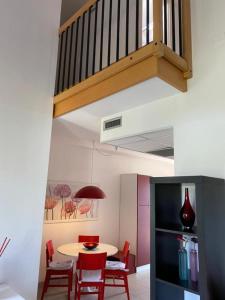 a dining room with a table and red chairs at residence Apuane in Cinquale
