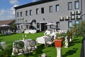 a building with tables and chairs in a yard at HOTEL N Residence in Timişoara