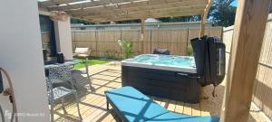 a hot tub in a backyard with a pergola at Apb Spa locations avec jacuzzi privatif in Saint-Jean-de-Monts