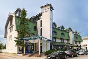 a hotel with cars parked in front of it at Best Palanga Hotel in Palanga
