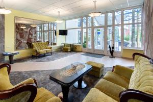 a waiting room with couches and a table and windows at Best Palanga Hotel in Palanga