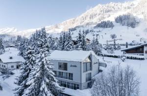 ザンクト・アントン・アム・アールベルクにあるOmaela Apartmentsの山の隣の雪に覆われた建物