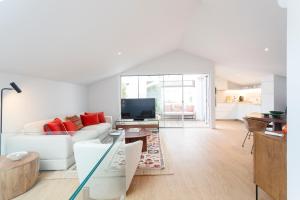a living room with a white couch and a tv at Cascais Center Luxury Triplex in Cascais
