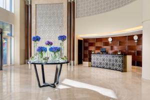 a lobby with a table with flowers on it at Grand Millennium Al Wahda Executive Apartments in Abu Dhabi