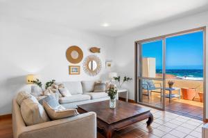 ein Wohnzimmer mit einer Couch und einem Tisch in der Unterkunft MEDANO4YOU Casa La Inglesa 5 in El Médano