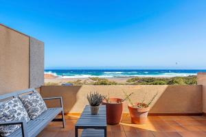eine Terrasse mit Tisch, Topfpflanzen und Strand in der Unterkunft MEDANO4YOU Casa La Inglesa 5 in El Médano